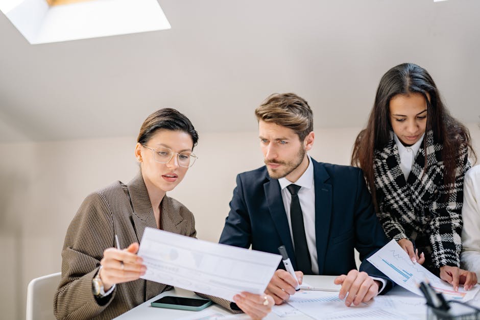 A group of employees reviewing documents in a modern office setting, fostering teamwork and collaboration.